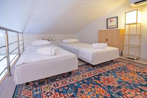 two beds in a room with a rug at Villa Taxiarchis by Corfuescapes in Benitses +43 photos