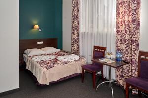 a bedroom with a bed and a table and chairs at Hostel Evotel in Zielonka