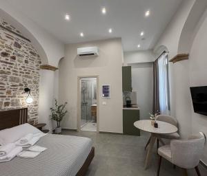 a bedroom with a bed and a table and a kitchen at Ralli 34 ROOMS&APTS in Chios