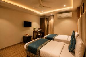 a hotel room with two beds and a television at The Waves Hotel with Free Airport Pickup or Drop in New Delhi
