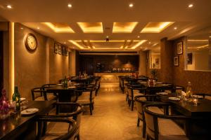 a restaurant with tables and chairs in a room at The Waves Hotel with Free Airport Pickup or Drop in New Delhi