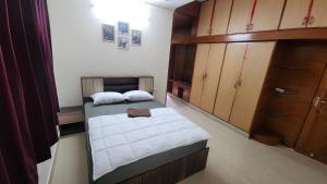 a small bedroom with a bed and wooden cabinets at BMK Inn in Bangalore
