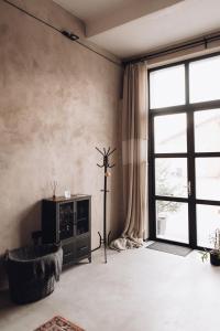 a living room with a large window and a chair at Maruse's Apartment in Kuldīga
