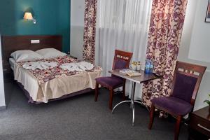 a hotel room with a bed and a table and chairs at Hostel Evotel in Zielonka