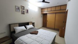 a bedroom with a bed with white sheets and a ceiling at BMK Inn in Bangalore