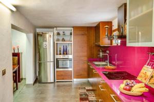 a pink kitchen with a sink and a stove at Casa del Callejon in Tejeda +16 photos