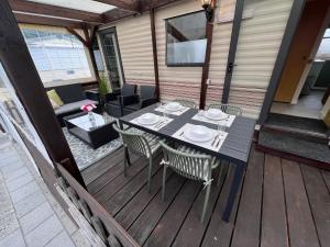 a table and chairs on a wooden deck at Zeester 91 in Scherpenisse