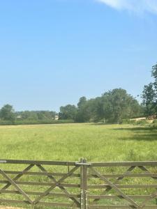 a fence in front of a field with trees at Astwell Mill Private accommodation near Silverstone in Helmdon +15 photos