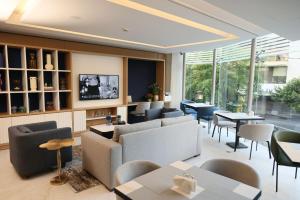 a restaurant with couches and tables and chairs at Staybridge Suites Beirut by IHG in Beirut