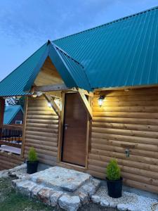 a wooden cabin with a blue metal roof at Stella Alpina in Žabljak