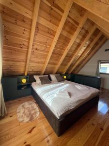 a large bed in a room with wooden ceilings at Stella Alpina in Žabljak