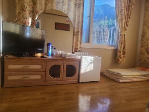 a living room with a television on a dresser at Sorak Garden Resortel in Sokcho