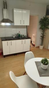 a kitchen with white cabinets and a table and chairs at Rooms in the center City in Barcelona +10 photos