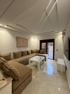a living room with a couch and a table at Studio marina smir in Marina Smir