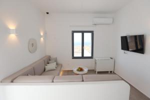 a living room with a couch and a tv at Liotrivi Luxury Residences in Kithnos