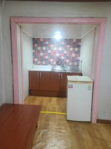 an empty kitchen with a sink and a refrigerator at Sorak Garden Resortel in Sokcho