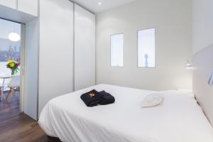 バルセロナにあるアパートメント パリ バルセロナの白いベッドルーム(帽子付きのベッド付)