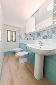 a bathroom with two sinks and a toilet at Rifugio Caretta in Montecorice