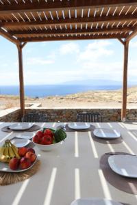 a table with fruits and vegetables on a table with the beach at Liotrivi Luxury Residences in Kithnos