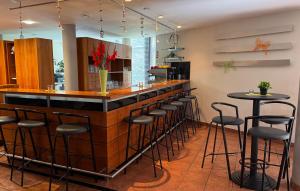 a bar in a restaurant with stools at a counter at Hotel Wörth in Wörth an der Isar