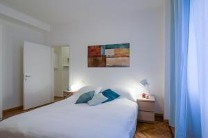 ミラノにあるThe Best Rent - Milan Cimiano Apartmentのベッドルーム(白いベッド、青い枕付)