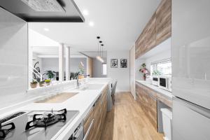 a kitchen with white counters and a stove top oven at The Prestige in Asahikawa