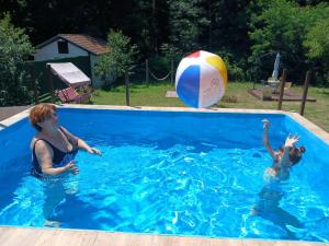 a woman and a child playing with a ball in a swimming pool at Etno domacinstvo Stankovic apartman br 2 in Gornji Milanovac +12 photos