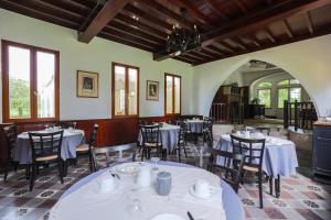 a dining room with white tables and chairs at Chalet des longschamps in Argoeuves