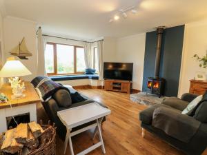 a living room with a couch and a fireplace at Thistle Do in Lochailort