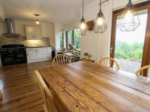a kitchen and dining room with a wooden table at Thistle Do in Lochailort