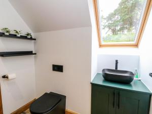 a bathroom with a black sink and a toilet at Thistle Do in Lochailort +49 photos