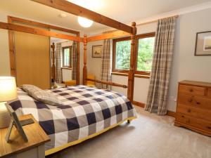 a bedroom with a bed and a desk and a window at Thistle Do in Lochailort