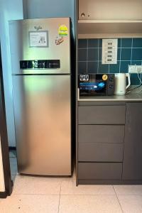 a stainless steel refrigerator in a kitchen next to a stove at GoStay Pods at Perak Road in Singapore