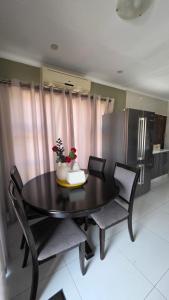 a dining room table with two chairs and a kitchen at The Manor in Manzini