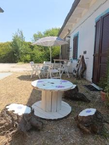 a table with an umbrella and a table and chairs at Loft immerso nel bosco in Rivola