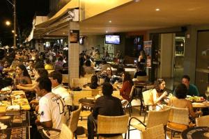 a group of people sitting at tables in a restaurant at Boulevard Park in Caldas Novas