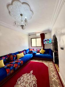a living room with a blue couch and a red rug at Romantic apartment near sea in Safi, Morocco in Safi
