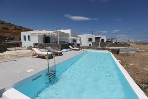a swimming pool in front of a villa at Liotrivi Luxury Residences in Kithnos
