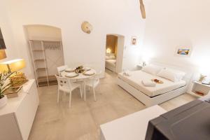 a white living room with a couch and a table at Luma Apartment Sperlonga in Sperlonga