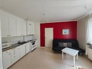 a kitchen with a black couch and a red wall at Ljusnefors Camping in Ljusne +9 photos