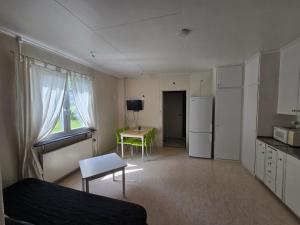 a room with a bed and a kitchen with a table at Ljusnefors Camping in Ljusne
