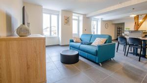 a living room with a blue couch and a table at Numéro 3 in Morvilliers +12 photos