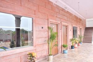 a red brick wall with potted plants on it at Nova Heaven Villa in Daijar