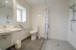 a white bathroom with a toilet and a sink at Numéro 3 in Morvilliers