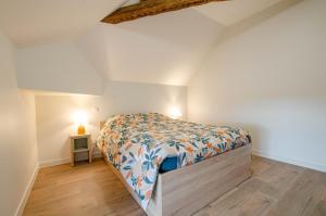 a bedroom with a bed and a lamp on a floor at Numéro 3 in Morvilliers