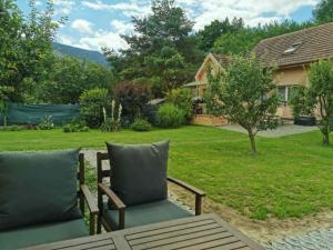eine Terrasse mit zwei Stühlen und einem Garten in der Unterkunft Privát SIMBA in Strečno