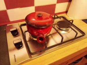 a red pot sitting on top of a stove at Chambres d'hôtes 05 Crévoux in Crévoux