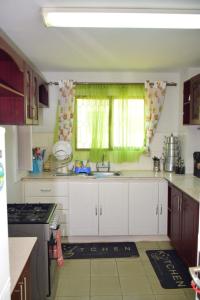 a kitchen with white cabinets and a sink and a window at Tsavo in Nairobi
