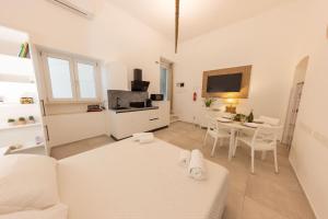 a white living room with a white couch and a table at Luma Apartment Sperlonga in Sperlonga