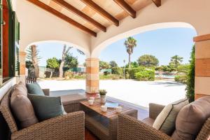 an outdoor patio with wicker furniture and a table at Casa Carlos - Villa en Son Cabrises in Cala Blanca